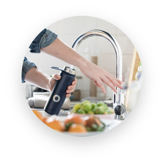 UNISUS Green Energy|A Resident Fills A Black Bottle with District Drinking Water from An In-room Smart Faucet