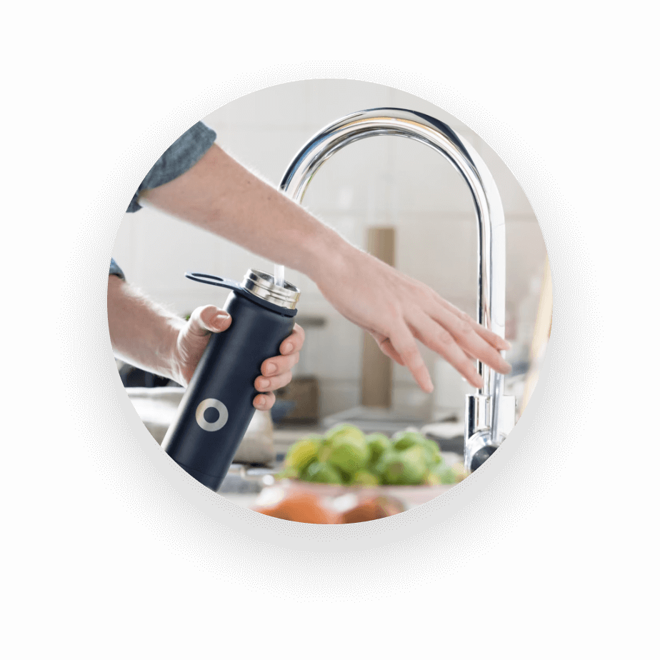 UNISUS Green Energy|A Resident Fills A Black Bottle with District Drinking Water from An In-room Smart Faucet